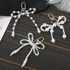 Handmade pearl bow keychain pendants in various beaded styles with gold lobster clasps