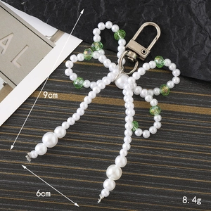 Pearl beaded bow charm with green glass beads for phones and bags, size 9x6cm