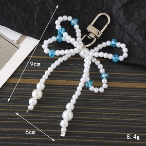 Detailed view of pearl bow keychain with dimensions 9cm x 6cm and weight 8.4g