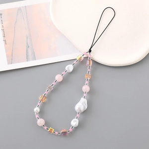 Elegant phone charm with baroque pearls and pink beads displayed on a ceramic plate