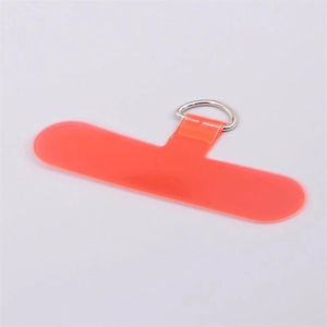 Macro detail of coral orange TPU phone tether tab with silver D-ring for lanyards