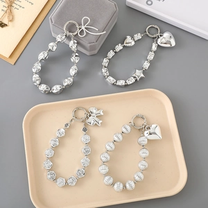 Silver beaded keychains with metal heart and bow charms in Y2K aesthetic