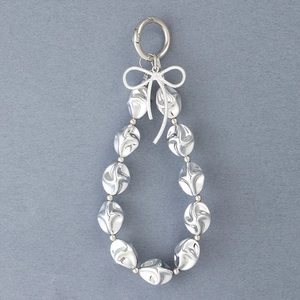 Detail of silver spiral textured beads with a bow accent on a metal keychain strap