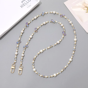 Macro shot of luxury crystal beaded chain with pearls and gold lobster clasps for bags