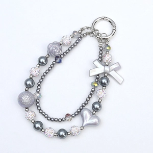 Double pearl chain keychain with bow and heart charms on a white background