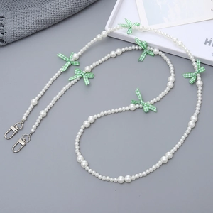 Detail of beaded crossbody phone chain with white faux pearls and green plaid bows