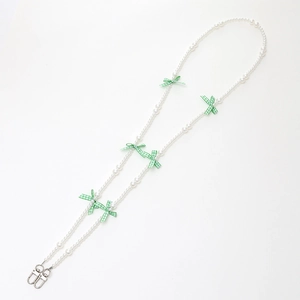 Pastel pearl phone strap with green plaid bows and silver lobster clasps on white background