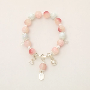 Detail of beaded bracelet with pink frosted beads and silver lucky cat lucky charms