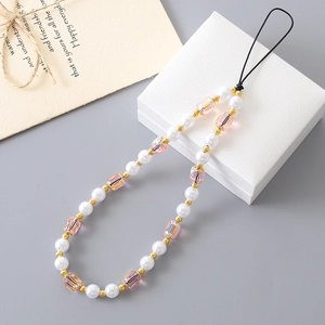 Chic phone charm with white faux pearls and pink crystal beads on a jewelry box