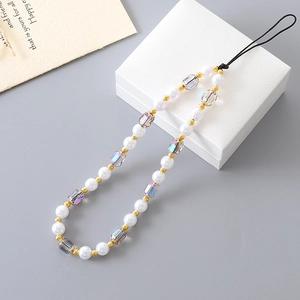 Close-up of elegant pearl and crystal beaded phone strap on textured gift box background