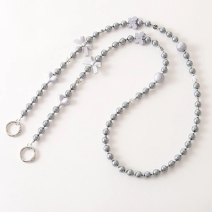 Detail of grey pearl phone strap with purple heart bow beads and silver spring clasps