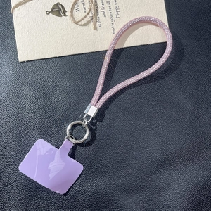 Detail of pink rhinestone phone lanyard with purple card and silver metal ring connector