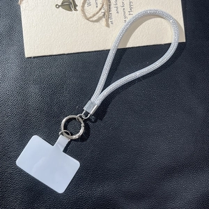 Close-up of sparkling silver rhinestone phone lanyard with a metal ring and plastic patch