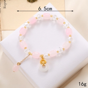Détail du bracelet en perles de cristal avec muguet et breloques roses et dorées