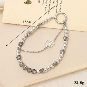 Crystal beaded keychain with silver butterfly pendant and metal chains in a tray