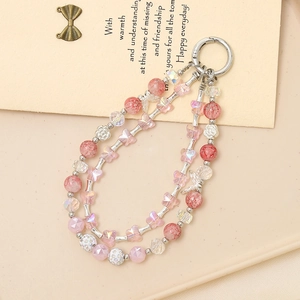 Detail of pink crystal beads with flower and butterfly charms for phone or bag strap