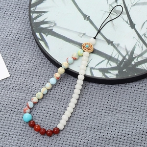 Detail of beaded phone strap featuring colorful stones and an antique decorative charm