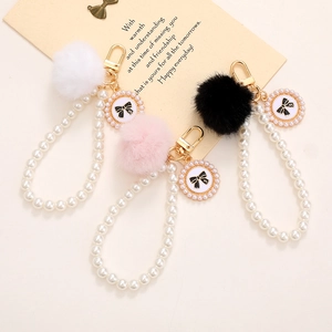 Elegante Portachiavi con Künstliche Perle d'Imitazione e Pallina di Peluche Ciondolo a Fiocco per Custodia Telefono Borsa Gioielli Regalo Donna