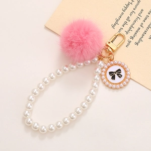 Chaîne de perles en verre avec pompon en fourrure rose et pendentif nœud noir