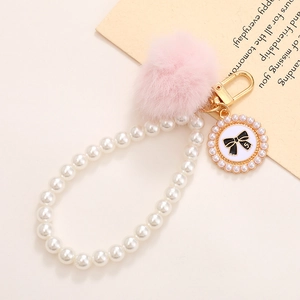 Détail de porte-clés en perles avec pompon rose et nœud pour décor de sac
