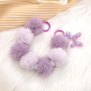 Purple plush ball keychain with colorful beads and a metallic balloon dog charm