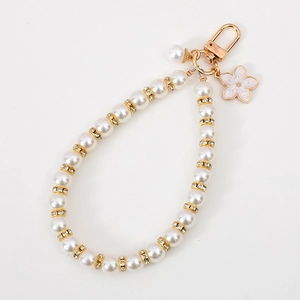 Elegant pearl keychain featuring gold rhinestone rings and a small pink flower charm