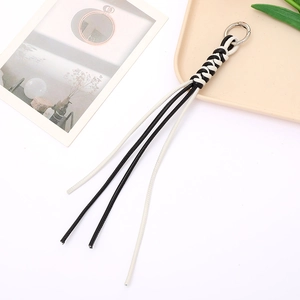 Detail of hand-woven black and white leather lanyard with silver round metal clasp
