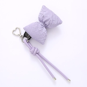 Detail of lavender puffer bow keychain with a silver heart clasp and leather lanyard