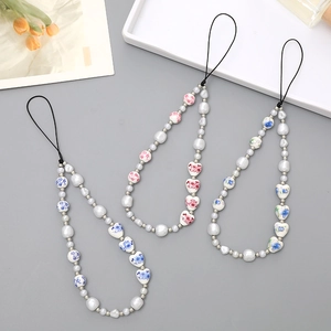 Elegant phone lanyard with faux pearls and floral painted heart-shaped ceramic beads
