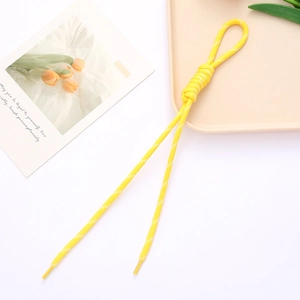 Macro shot of bright yellow braided rope strap with white speckles and plastic aglets