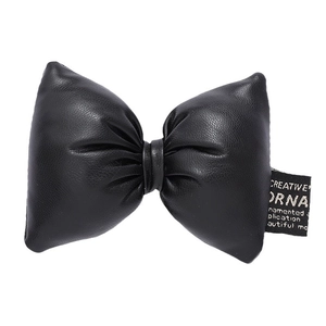 Three-dimensional black faux leather bow accessory with decorative label and fine texture
