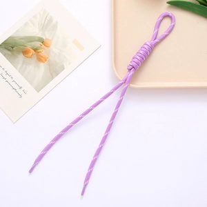 Detailed macro view of a purple woven cord keychain with decorative roman knot design