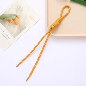 Detail of ginger yellow woven lanyard cord with a secure loop and white striped patterns