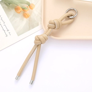 Beige DIY braided leather keychain with silver metal ring and decorative white stitching