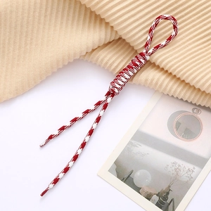 Detail of red and white houndstooth woven rope with reinforced loop and plastic tips