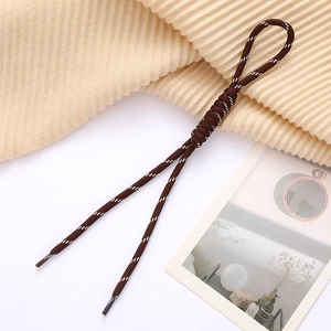 Detail of coffee brown braided cord with roman knot and clear plastic ends for accessories