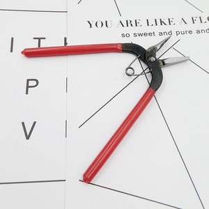 Detail of red needle-nose jewelry pliers with spring action for DIY phone case crafting