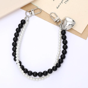 Detail view of double-strand pearl phone strap with silver heart charm and lobster clasps