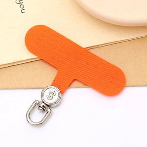 Close-up of orange fabric phone tether tab with a rotating silver metal dollar sign hook