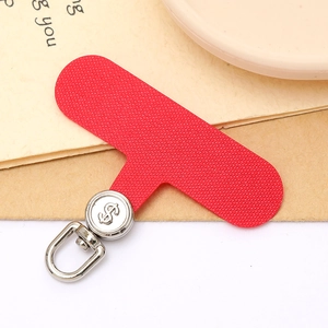 Detail view of red T-shaped phone tether tab with silver rotating dollar sign buckle