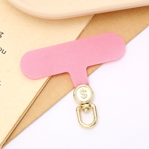 Pink fabric phone tether tab with golden rotating dollar sign metal ring close-up