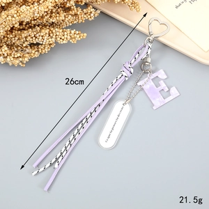 Detail view of purple marble letter E keychain with braided tassel and heart clasp