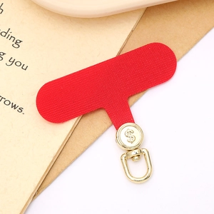 Detail of red fabric phone tether tab with golden metal swivel clip and dollar sign