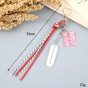 Close-up of a 26cm woven rope tassel keychain with letter H and pink marble stone pendant