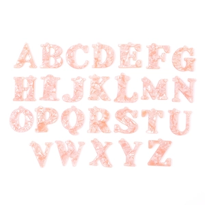 Macro view of 26 pink marble texture acrylic alphabet charms with integrated hanging holes