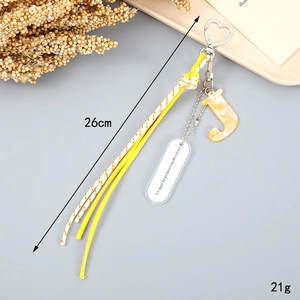 Detail view of woven yellow rope keychain with marble letter J charm and heart clasp