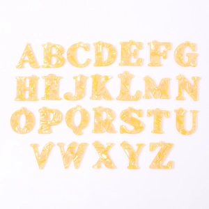 Set of 26 amber acrylic alphabet charms with marble texture and integrated top loops