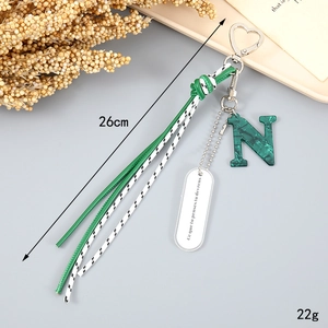 Detail showing the green braided rope keychain with letter N and French inscription