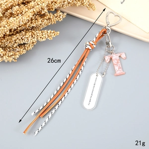Letter T keychain with orange woven rope and pink marble pendant detail, 26cm length