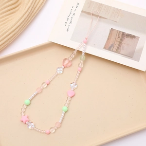 Charming pastel acrylic beaded phone strap with pink heart and star charms on beige tray